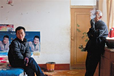 父親抽煙，兒子不語。逃跑的越南新娘，給袁迎賓父子帶來的是失落。新京報記者