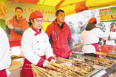賣羊肉串?dāng)偽焕习遐w山（穿紅衣者）。新京報記者