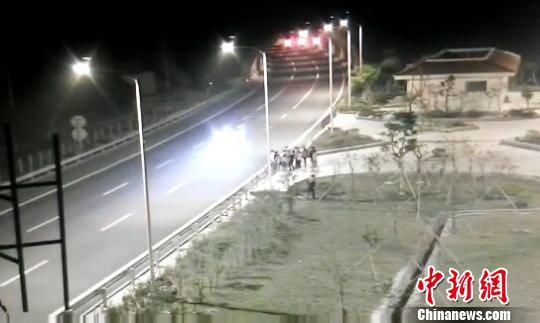 看到車輛經(jīng)過，孩子們便急忙跑到一旁的花圃上?！【焦﹫D　攝