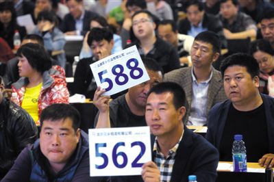 昨日，拍賣現(xiàn)場競拍者舉牌競拍。新京報記者