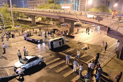 路虎沖下國貿橋砸中一輛起亞轎車，橋上厚達幾十厘米的水泥護欄被撞斷，碎石四處散落，數(shù)十群眾在現(xiàn)場圍觀。