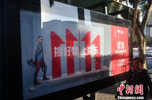 資料圖：11月1日，福州民眾從雙十一廣告牌前經(jīng)過。中新社記者 呂明 攝