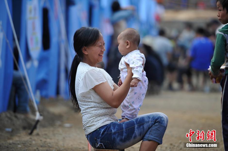 8月6日，一名年輕的母親在和孩子玩樂。