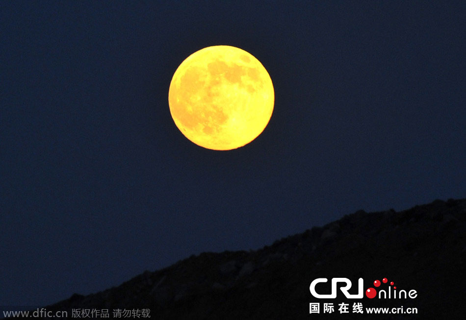 8月10日晚，一輪金燦燦的大月亮在遼寧省大連市東方升起。圖片來源：劉德斌/東方IC