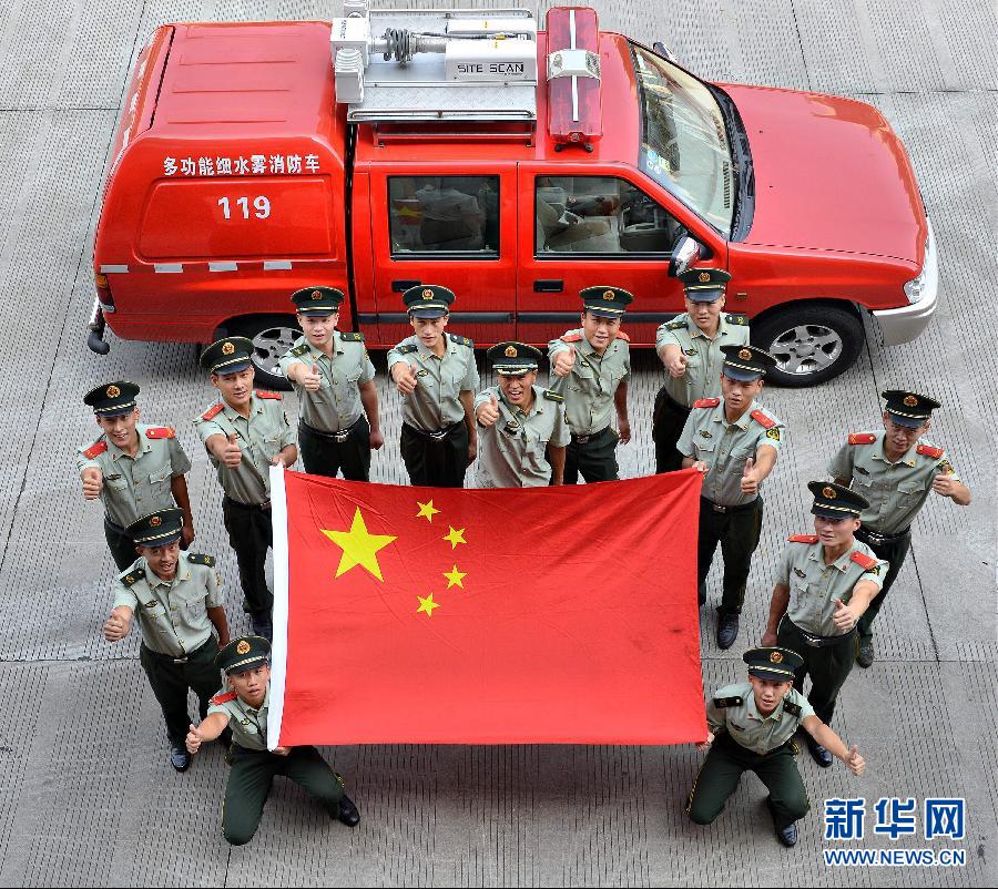  9月25日，武警浙江嘉興消防官兵與國旗合影。