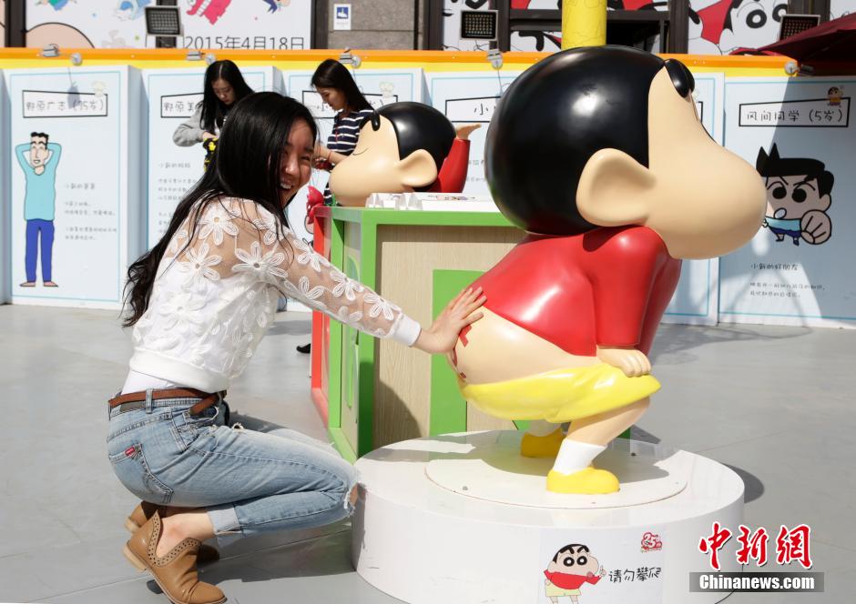 4月22日，游客與蠟筆小新合影?！跋灩P小新25周年紀(jì)念特展”日前在北京開(kāi)展，吸引了不少市民游客。