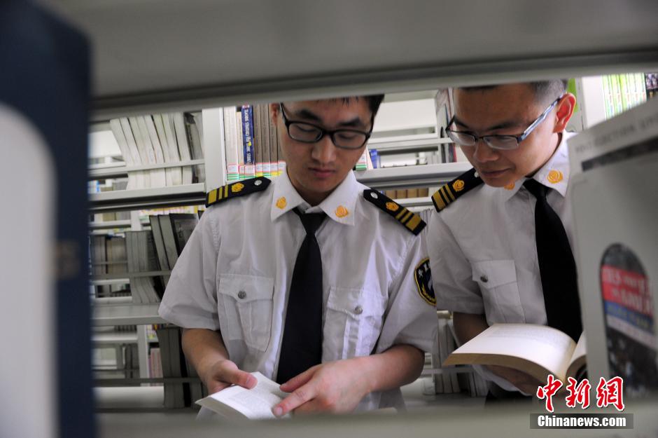 5月8日，武漢輕工大學(xué)圖書館保安吳濤與江力在圖書館交流學(xué)習(xí)。