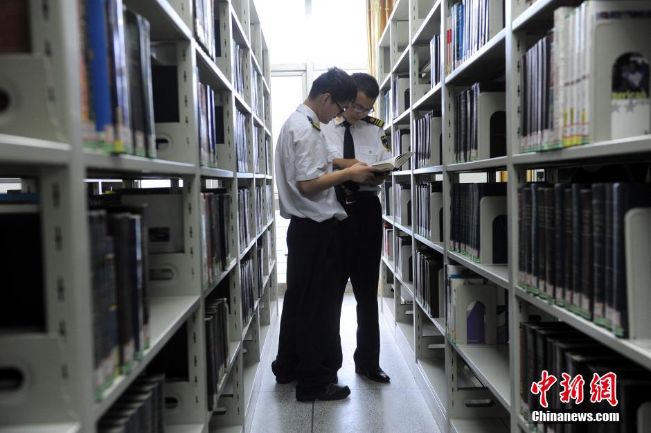 5月8日，武漢輕工大學(xué)保安吳濤與江力在圖書館交流學(xué)習(xí)。中新社發(fā) 張暢 攝