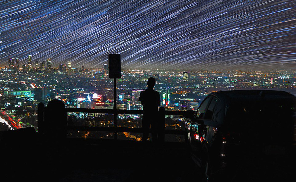 照片中，一名男子看著流星和隕星劃過天空。（網(wǎng)頁截圖）