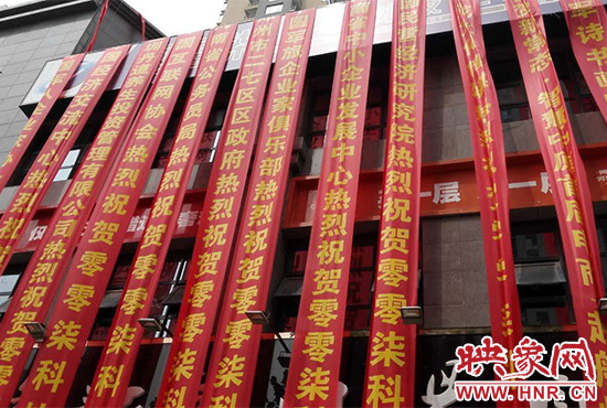 路邊一棟樓上懸掛著二三十條紅色條幅，全部是祝賀一家公司開業(yè)的。