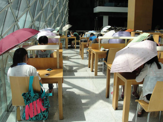 2015年8月2日，深圳圖書館，“太陽曬進(jìn)來很熱的，我們都要撐著傘讀書。”