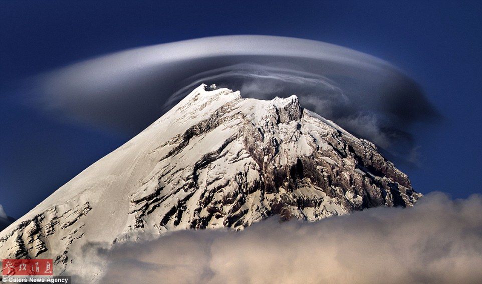 火山上籠罩著類似于外星飛碟形狀的云彩，場景猶如科幻大片。