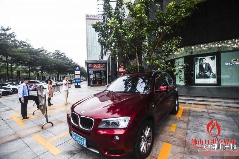 一輛停在停車位上的寶馬轎車，被墜落的樹枝砸中，樹枝徑直插入車內(nèi)，現(xiàn)場(chǎng)引發(fā)不少市民圍觀拍照。
