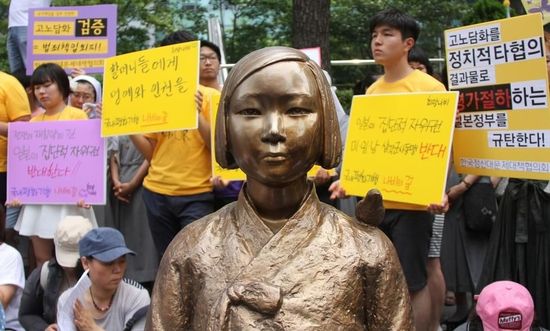 7月2日，在韓國(guó)首爾的日本駐韓國(guó)大使館前，民眾在慰安婦少女像旁手持標(biāo)語(yǔ)參加抗議活動(dòng)。