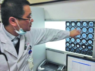 醫(yī)生在查看男孩的腦部CT片。薛馬義 攝