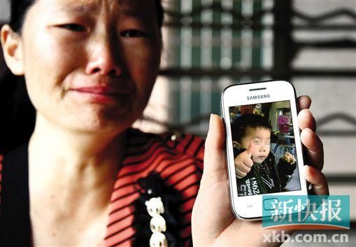 男童的舅媽拿著小益的照片,悲痛欲絕。 新快報記者 畢志毅 攝