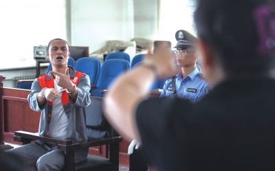 張志國在法庭上用手語回答提問。記者 蒲東峰攝