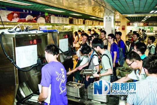 昨日，華南理工大學(xué)一食堂內(nèi)，學(xué)生們正在使用新安裝的自動(dòng)打飯機(jī)打飯。中新社發(fā)