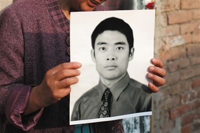 5月19日，朝陽(yáng)北路，母親捧著張東文的遺像。新京報(bào)記者 侯少卿 攝