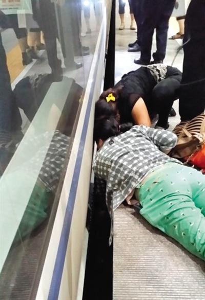 一女子趴在站臺(tái)上，救跌入列車和站臺(tái)間隙的男童。網(wǎng)友璀璨的星月夜 攝