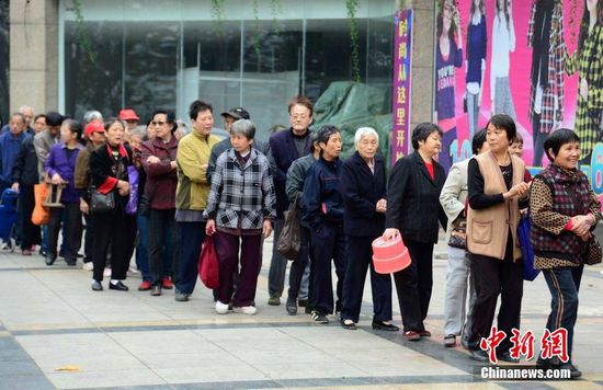 圖為10月28日，在江西九江市一家羊絨皮草服裝服飾博覽會現(xiàn)場，老人們正在頂著寒風排隊等待領(lǐng)取10元代金劵。