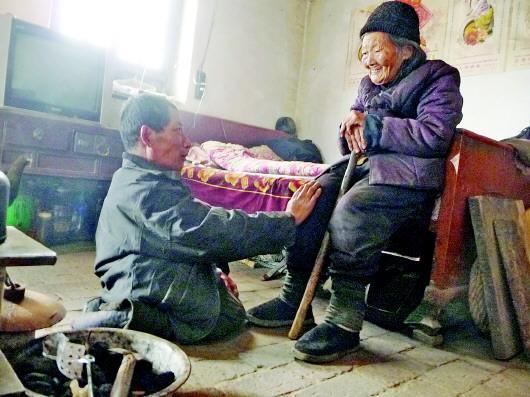 52歲的劉蘭山每天靠爬行照顧90歲的老母親。孫國祥 攝