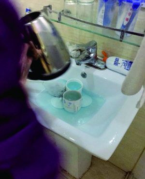 酒店服務員用潔廁液刷燒水壺和茶杯。