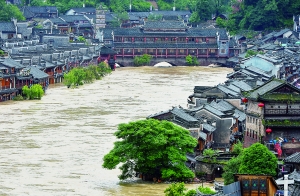 7月16日,沱江兩邊的商鋪和遠(yuǎn)處的虹橋仍淹沒在洪水中。 新華社發(fā)