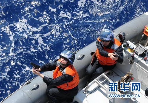 　3月28日，十余名臨檢拿捕隊員乘小艇駛至模擬可疑商船下方水面。