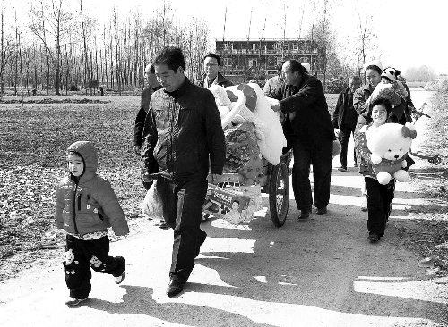 姐（左一）弟（右一護士懷中男嬰）返鄉(xiāng)，愛心捐贈滿滿一架子車。