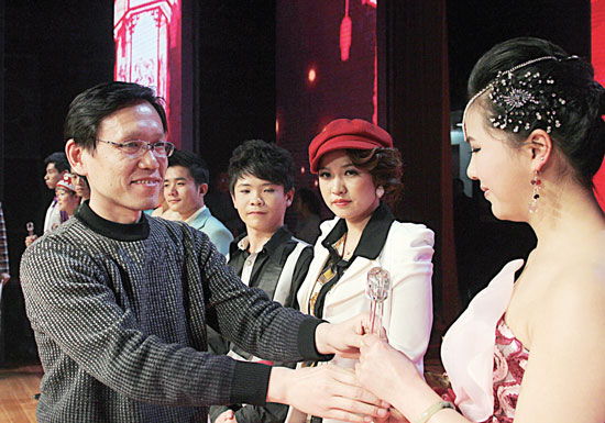 2013年2月1日，《對9當(dāng)歌》總決賽在鄭州開唱。圖為東方今報(bào)副社長胡楊為選手頒獎(jiǎng)