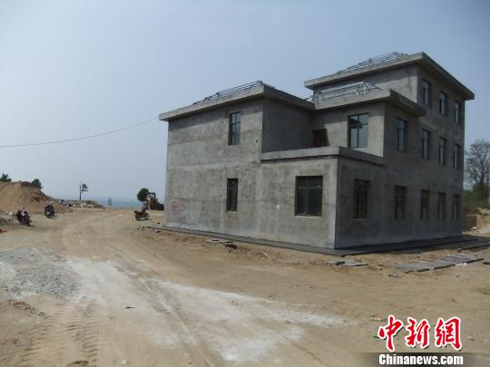 鴨河水庫庫區(qū)邊的新建別墅，一面墻上寫著“拆”，另一邊在加緊施工。吳揚　攝