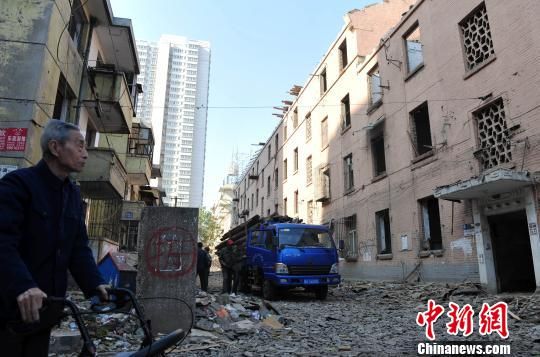 一位花甲老人站在即將拆除的樓房旁，默默地與“蘇聯(lián)樓”告別?！〉杂鸺选z